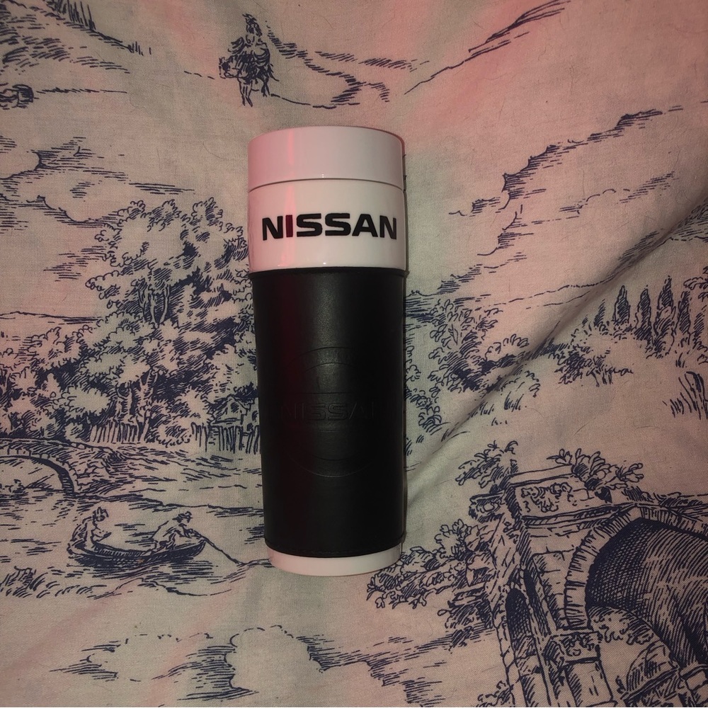 NISSAN Porcelain Travel Mug Blk Faux Leather Sleeve W/ Nissan Logo Embossment.